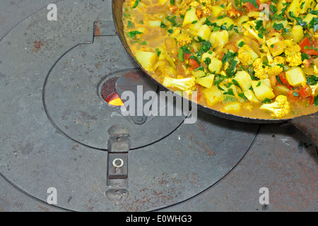 Le légume de cuisson sur four en fonte au bois Banque D'Images