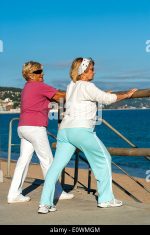 Les femmes âgées les étirements avant le jogging. Banque D'Images