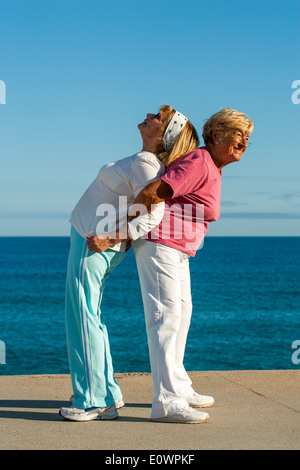 Seniors femmes d'aider les uns les autres d'étirement. Banque D'Images