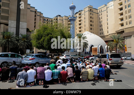 Beaucoup d'hommes prier le vendredi à la mosquée de l'extérieur du centre commercial Burjuman à Dubaï Émirats Arabes Unis Banque D'Images