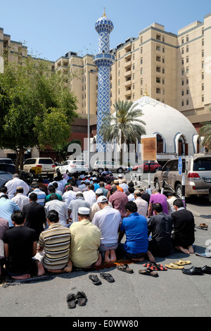 Beaucoup d'hommes prier le vendredi à la mosquée de l'extérieur du centre commercial Burjuman à Dubaï Émirats Arabes Unis Banque D'Images