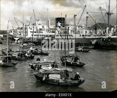 Septembre 09, 1964 - une grande quantité de la richesse de Hong Kong vient de son port libre, occupé 31,788 navires d'un tonnage total de 25.756.509 appelé l'an dernier. Comme chaque navire arrive, elle est immédiatement entouré par les sampans remplis de réfugiés chinois qui espèrent travailler dans le chargement et le déchargement comme ces hommes attendent dans leur bateaux. Banque D'Images