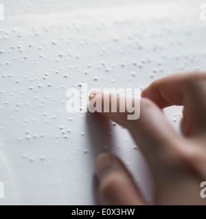 Un doigt sur le dessus d'un livre en braille lecture Banque D'Images