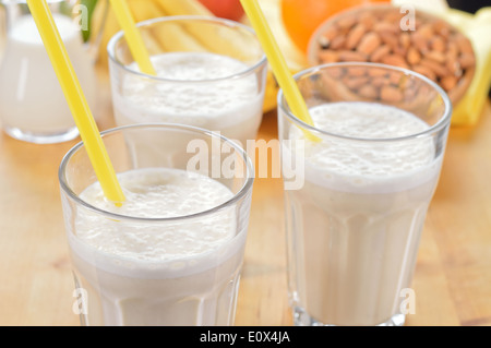 La banane et le lait d'amande smoothie dans un verre sur une table de cuisine. Boisson d'été fait de la banane, le lait d'amande et quelques dactyl. Banque D'Images