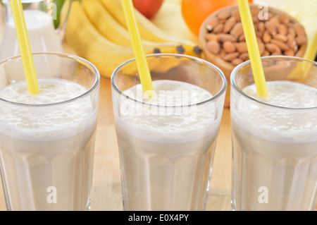 La banane et le lait d'amande smoothie dans un verre sur une table de cuisine. Boisson d'été fait de la banane, le lait d'amande et quelques dactyl. Banque D'Images