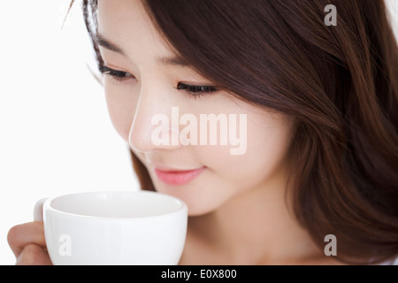 Une femme boire d'une tasse blanche Banque D'Images