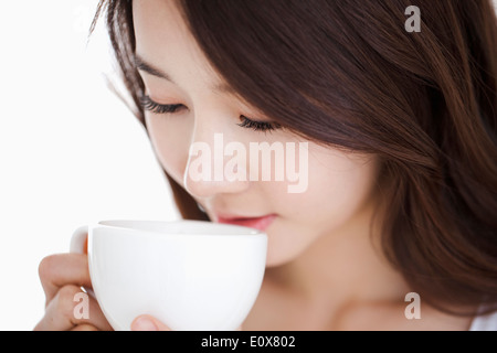Une femme boire d'une tasse blanche Banque D'Images