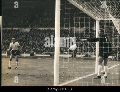 Juillet 07, 1966 - Coupe du Monde de Football l'Angleterre contre l'Allemagne à Wembley la finale de la coupe du monde : photo montre l'Angleterre Geoffrey Hurst saute en l'air avec joie qu'il marque le premier objectif de l'Angleterre, sur la gauche est l'Allemand full retour Willie Schulz et debout dans son but est l'Allemand pointant la main de gardien Tilkowski. Banque D'Images