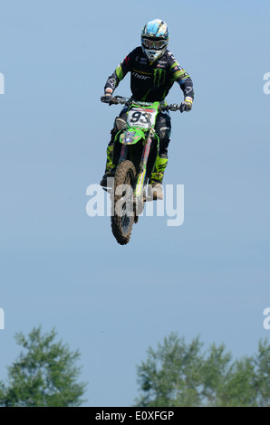 Le motocross est une forme de course de moto qui a eu lieu sur les circuits tout-terrain clos. Un motard sur moto scramble, sauter haut dans ciel bleu Banque D'Images