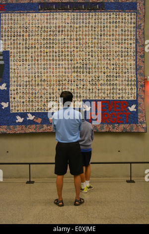 Les personnes à la recherche à une courtepointe à l'échelle nationale 9/11 Memorial Museum à Ground Zero. Banque D'Images