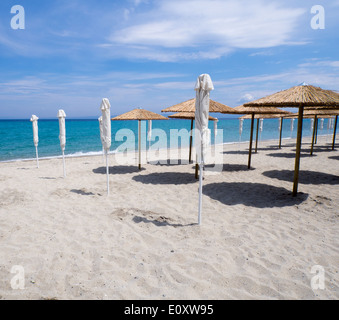 Parasols sur une plage de sable déserte Banque D'Images