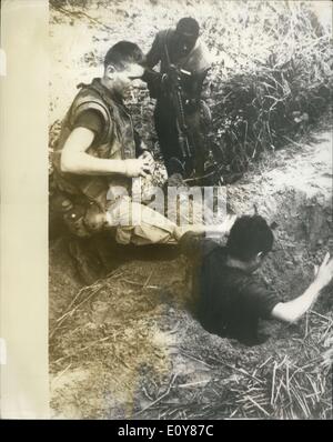 14 janvier 1969 - Rincer un ''Renard''. Un Viet Cong sniper est éjectée de son trou par deux Marines des États-Unis à 22 miles au sud de Da Nang. Le milieu marin a fumer une cigarette tranquillement ses mains autour d'une grenade prête à tirer l'axe si le détenu a des amis dans l'abri souterrain qui ne sort pas, tandis qu'un autre couvre l'homme marine avec son fusil automatique. Banque D'Images