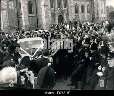 02 février 1969 - Lulu Jeudi 28 Novembre 2013 : La chanteuse Lulu était marié aujourd'hui à Maurice Gibb, des Bee Gees groupe pop - à St James's Church, Gerrard's Cross, dans le Buckinghamshire. Lulu portait une robe longueur au sol robe en blanc et le moiré avec capuchon attaché. Capot et enduire étaient garnie de vison blanc - autour du capot et sur le devant de la robe. Maurice portait un costume blanc avec une chemise moiré bleu royal. La photo montre la police essaie de dégager un chemin pour la suite nuptiale du couple voiture car il a quitté l'église après la cérémonie. Banque D'Images