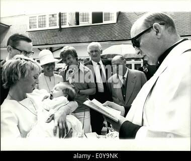 Juin 06, 1969 - La Fille de Tommy Steele baptisé la fille de Tommy Steele, Emma Elizabeth, a été baptisé aujourd'hui lors d'une cérémonie privée dans le jardin de leur maison, Teddington. La cérémonie a été effectué par le Père John Bebb, qui officia au mariage d'aujourd'hui. Photo montre : Le Père John Bebb effectue la cérémonie de baptême alors que Emma Elizabeth son emprise dans les bras de Polly James, sa marraine, qui a comparu avec Tommy dans ''La moitié d'un Sixpence'' à New York. À la recherche sur sont les fiers parents, Tommy et sa femme Ann. Banque D'Images