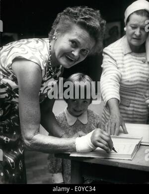 08 août 1969 - Joy Adamson est titulaire d'exposition de ses images : Joy Adamson, auteur de Born Free, l'histoire d'Elsa la lionne, a ouvert aujourd'hui une exposition de ses peintures à l'Inde Plateau Centre, Oxford Street, Londres, aujourd'hui. Mme Adamson, l'artiste, qui s'est blessée à la main droite dans un accident de voiture à Nairobi en janvier, peuvent ne jamais peindre. Elle a eu un traitement pour elle dans ce pays. La photo montre la joie Adamson signe une copie autographe de Born Free, avec sa main blessée, pour quatre ans Mary Mackenzie, aujourd'hui. Banque D'Images