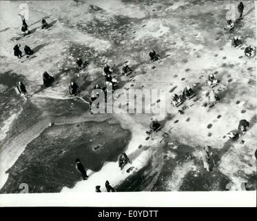 01 janvier, 1970 - la pêche d'hiver en Corée : vue montrant les pêcheurs sud-coréen à travers les trous de la glace, ce de la rivière Han gelé près de Séoul. Assis sur des caisses en bois, les pêcheurs laissaient tomber leurs lignes et d'hameçons sur des bobines qui ressemblent à des grilles sur un manche et placé sur le trou dans la glace, et d'attendre que les piqûres. Banque D'Images