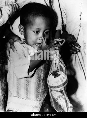 01 janvier 1970 - Phan Rang, Vietnam - un enfant vietnamien inspecte les jouets donnés par la 1ère Brigade de la 101e Division aéroportée à 400 enfants dont les pères servent dans les forces vietnamiennes. Dans les années 1950, les États-Unis ont commencé à envoyer des troupes au Vietnam, au cours de la période de 25 ans, la guerre qui s'en pourrait créer certaines des plus fortes tensions dans l'histoire des Etats-Unis. Près de 3 millions d'entre nous hommes et femmes ont été envoyés combattre pour ce qui a été une cause douteuse. Au total, on estime que plus de 2,5 millions de personnes des deux côtés ont été tués. Banque D'Images