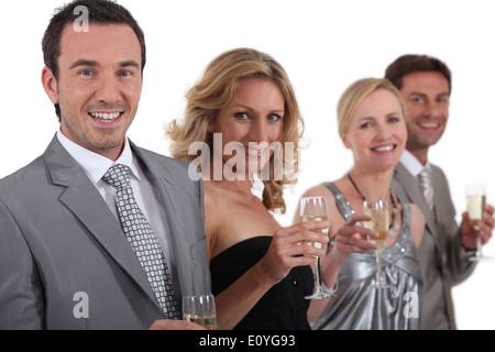 Des couples standing holding champagne Banque D'Images