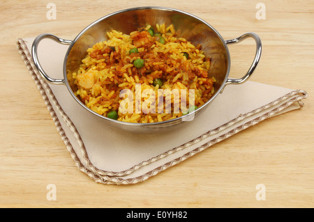 Biryani d'agneau balti dans un plat avec un serviette sur une table en bois Banque D'Images