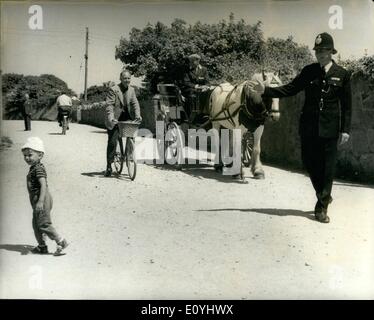 Juin 06, 1970 - Sark's premier policier ; le contrôle de l'heure de pointe sur l'île de Sark, la minuscule île Channel paradise, où il n'y a pas de voitures, n'est P.C.Thomas Birch - vu la tenue d'un poney et de piège et un cycliste, pour permettre à un petit garçon à traverser. C.p. - Sarks de bouleau - premier policier arrivé sur l'île d'hier sur le détachement de deux semaines à partir de l'île voisine de Guernesey, d'aider à mettre un terme à la vague de criminalité Sark au moins il semble comme une vague de crimes à l'habitants pacifiques - rosiers tiré vers le haut, cycles falsifié et chariots électroniques briser le 5 m.p.h Banque D'Images