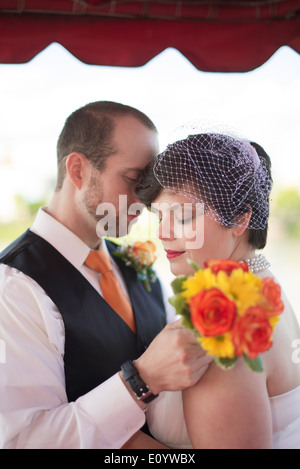 Couple nouvellement marié avec un bouquet de fleurs Banque D'Images