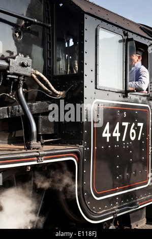 Un conducteur de train sur la plaque d'assise d'un moteur à vapeur Banque D'Images