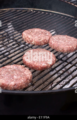 La cuisson des hamburgers sur un feu de charbon de barbecue Banque D'Images