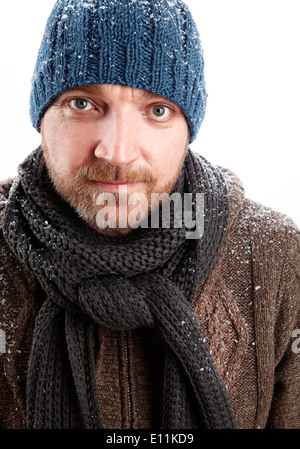 Portrait d'un homme séduisant avec chapeau bleu dans la neige Banque D'Images