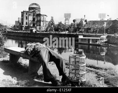 Mar 29, 2006 ; Hiroshima, Japon ; (Photo : date inconnue) un Japonais prend une sieste sur un banc dans le parc de la paix, tandis que l'autre côté de la rivière se trouve les ruines de la galerie d'exposition industrielle qui était juste sous le point d'explosion de la bombe. Alors que le reste d'Hiroshima a été reconstruit, ce bâtiment sera préservé comme un sombre rappel de la catastrophe. (Crédit Image : KEYSTONE/ZUMAPRESS.com) Photos USA Banque D'Images
