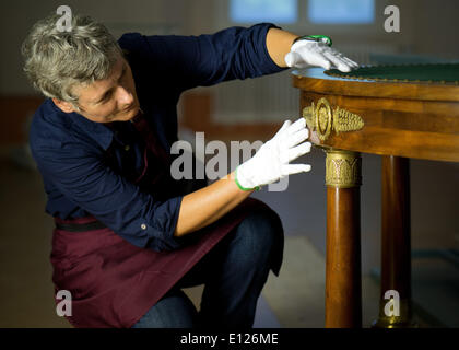 Doberlug-Kirchhain, Allemagne. 21 mai, 2014. Un restaurateur Sei Seiler vérifie la table du château de Valençay en France est mis en place à Doberlug Palace à Doberlug-Kirchhain, Allemagne, 21 mai 2014. Le bouche à oreille l'a que l'acte final du Congrès de Vienne a été signé sur la table il y a 200 ans. Le tableau a été prêté à l'état de Brandebourg première exposition est présentée du 07 juin au 02 novembre 2014. Photo : ARNO BURGI/dpa/Alamy Live News Banque D'Images