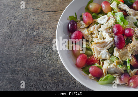 Mélanger avec la salade de poulet et les raisins sur le plat blanc Banque D'Images