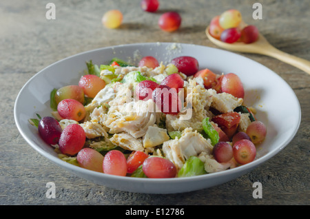 Mélanger avec la salade de poulet et les raisins sur le plat blanc Banque D'Images