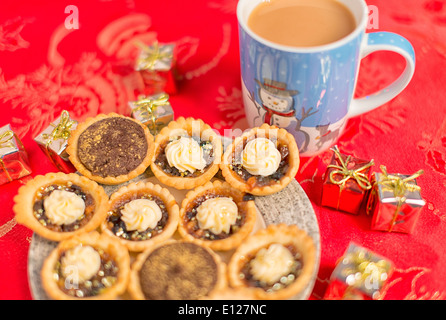 hachez les chaussons sur l'assiette sur la nappe rouge festive Banque D'Images