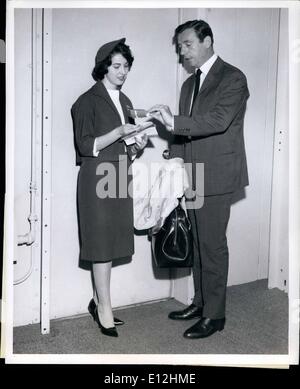 04 janvier 2012 - L'AÉROPORT INTERNATIONAL DE NEW YORK. Frenoh populaire acteur Yves Montand a sa carte d'embarquement contrôlée par une belle hôtesse TWA Pat : avant d'embarquer son Superjet TWA à Los Angeles. Monsieur Montand marié à Academy Award Winner Simone Signoret, arrivé de Paris il y a deux jours. Banque D'Images