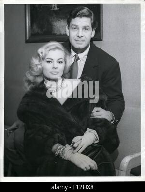 24 février 2012 - L'aéroport Idlewind, N.Y., 12 avril. Belle Anita Ekberg et son mari, l'acteur Anthony Steele, illuminera la scène de New York pour quelques heures aujourd'hui avant de tourner leur façon de Lisbonne pour une photo de décisions. Ils sont vus ici suivant leur arrivée via TWA de Los Angeles. Banque D'Images