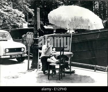 24 février 2012 - L'été à Amsterdam : une jeune fille se détendre au soleil au bord des canaux d'Amsterdam à l'écart de l'animation de la ville et des embouteillages. Banque D'Images