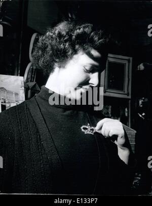 Le 26 février 2012 - Dans un magasin de souvenirs à Trafalgar Square, Mlle Joyce Powell tente sur une broche en pâte en forme de couronne, l'un des souvenirs populaires de l'année du couronnement. Couronnement de souvenirs pour les visiteurs étrangers : dès que la date du couronnement a été annoncé les fabricants ont commencé à faire des souvenirs et cadeaux et maintenant air souve magasins de Londres et d'autres grandes villes sont déjà en train de faire une marche rapide du commerce, en particulier avec des visiteurs de l'étranger, qui, bien qu'ils ne seront pas en Angleterre l'an prochain pour le Couronnement, veulent prendre de souvenirs retour à l'accueil avec eux Banque D'Images