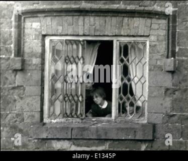 Le 26 février 2012 - Photo montre : Trois des enfants vus à l'un des chalet windows. John James, le Shropshire a émergé l'homme pour la première fois de contacter les autorités. Il portait son fusil sous son bras. James marcha six pas d'un cabanon à mur et recueilli une miche de pain, une boîte de pain de viande, et de l'eau laissée par M. Tom Hadlington, son beau-frère. Il est maintenant six jours que James barricadé dans la maison avec sa femme Joyce et quatre jeunes enfants. Banque D'Images