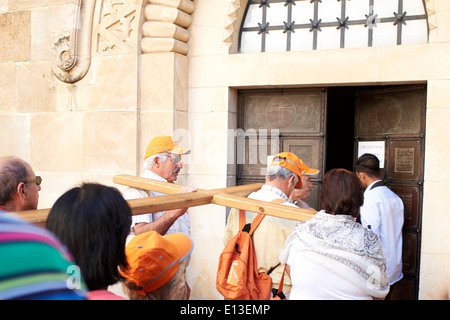 Pèlerins portant une croix sur la Via Dolorosa dans Jérusalem, Terre Sainte Banque D'Images