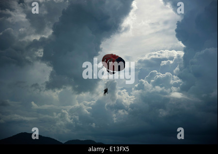 Parapente en pluies de mousson et les nuages de tempête sur la plage de Batu Feringgi, l'île de Penang, Malaisie, Asie du Sud Est Banque D'Images