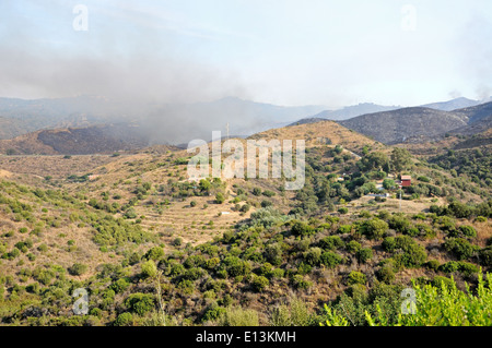 La fumée s'élevant dans la campagne andalouse, Mijas, Costa del Sol, la province de Malaga, Andalousie, Espagne, Europe de l'Ouest. Banque D'Images