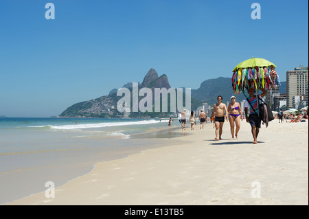 RIO DE JANEIRO, Brésil - Mars, 2013 : vente du vendeur de plage bikinis marche dernières matin les personnes fréquentant les plages la plage d'Ipanema Rio de Jane Banque D'Images