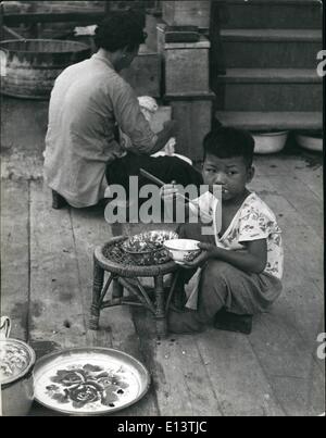 27 mars 2012 - le petit garçon réfugié à son bol de riz conserve son œil sur l'approche de l'étranger qui sont probablement des touristes et ils sont en ligne pour mendier quelques pièces de monnaie. Tous les touristes sont sa cible. Banque D'Images