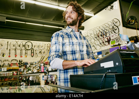 Caucasian man travaillant dans magasin de bicyclettes Banque D'Images