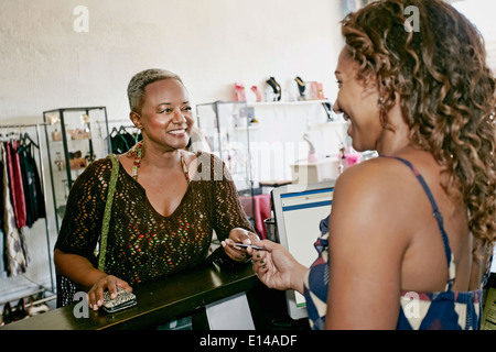 Femme de payer en magasin Banque D'Images