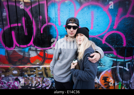 Caucasian mother and son hugging par le graffiti wall Banque D'Images