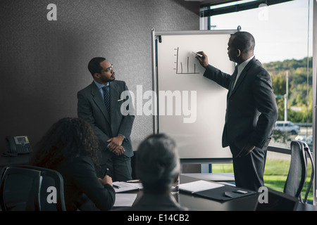 Businessman talking to colleagues in meeting Banque D'Images