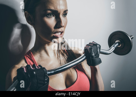 Close up of Caucasian woman lifting barbell Banque D'Images