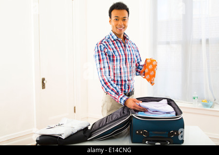 Mixed Race woman packing suitcase Banque D'Images