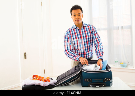 Mixed Race woman packing suitcase Banque D'Images